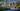 Pleasant night render of a residential complex from the park side, showcasing people strolling by